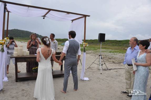 Os padrinhos (o casal 1000dias!!!) leem um texto em homenagem aos noivos durante a cerimônia de casamento na Praia Grande, na Ilha do Mel, no litoral do Paraná